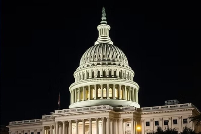 The U.S. Capitol dome floodlit against a black sky
