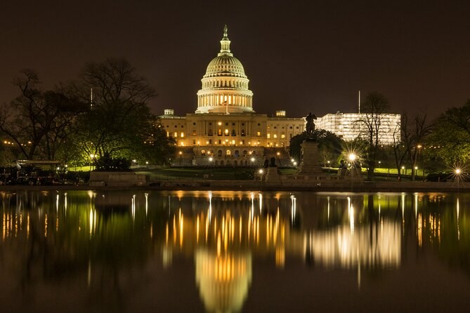 The Capitol lit up and reflected in still water at night